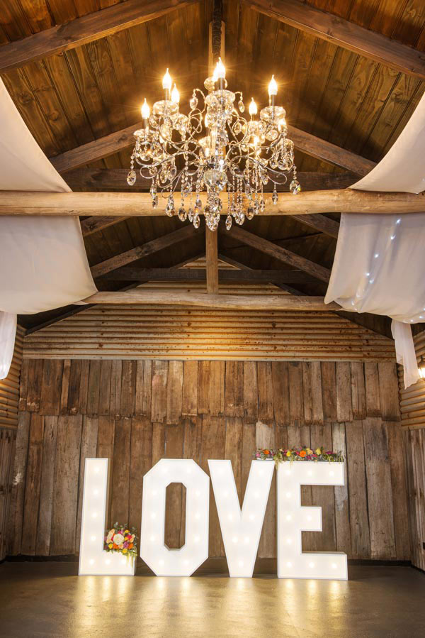 Love abounds under the glittering chandalier inside The Stables